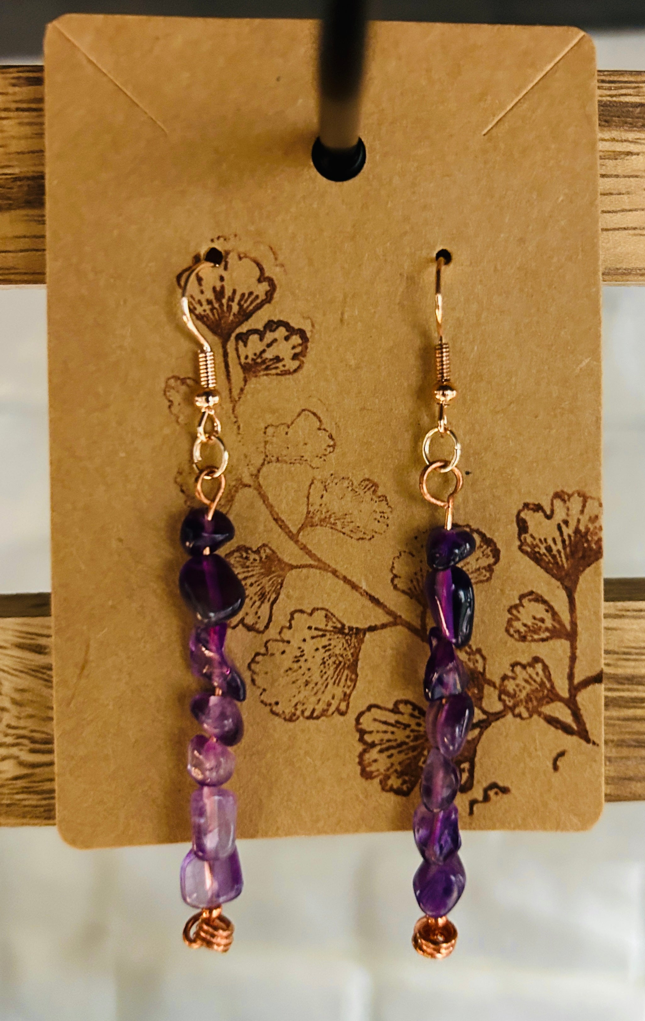 Rich purple amethyst nugget stone bead and copper earrings on a brown paper display card 