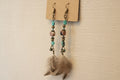 Pair of dangling bronze earrings with turquoise and agate beads with  brown feather accents