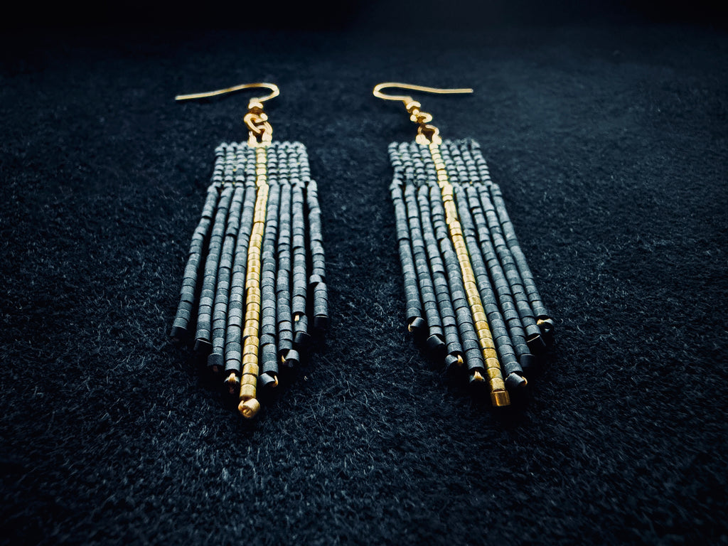 Matte Black & gold beaded fringe earrings on a black background