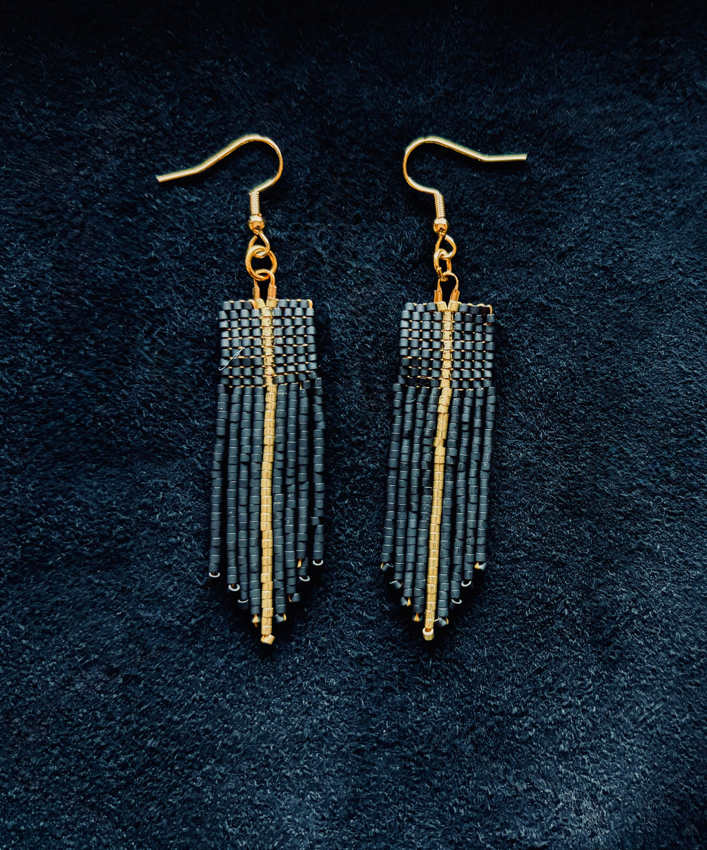 Matte Black & gold beaded fringe earrings on a black background