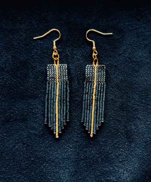 Matte Black & gold beaded fringe earrings on a black background
