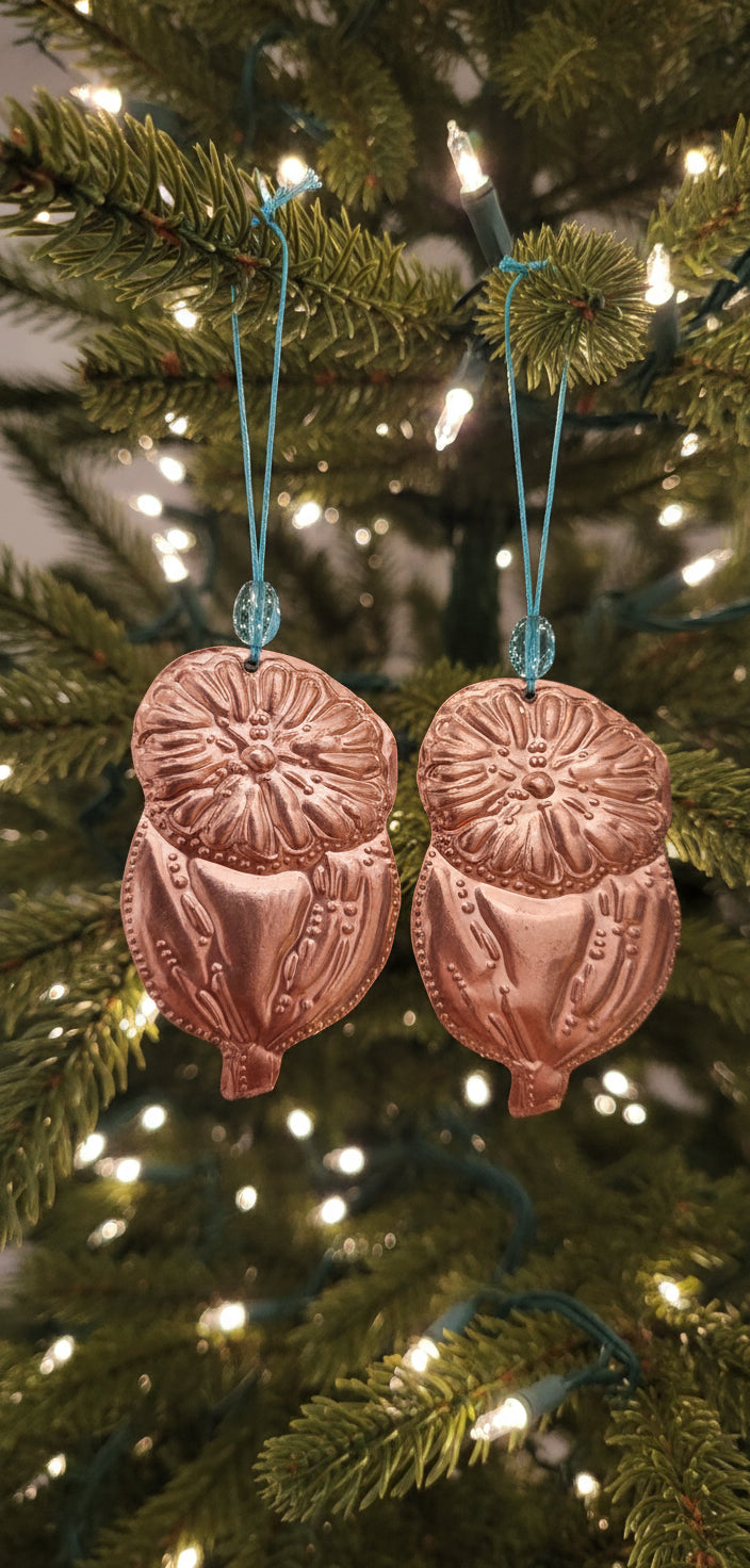 Decorative copper ornaments on a dark background with greenery