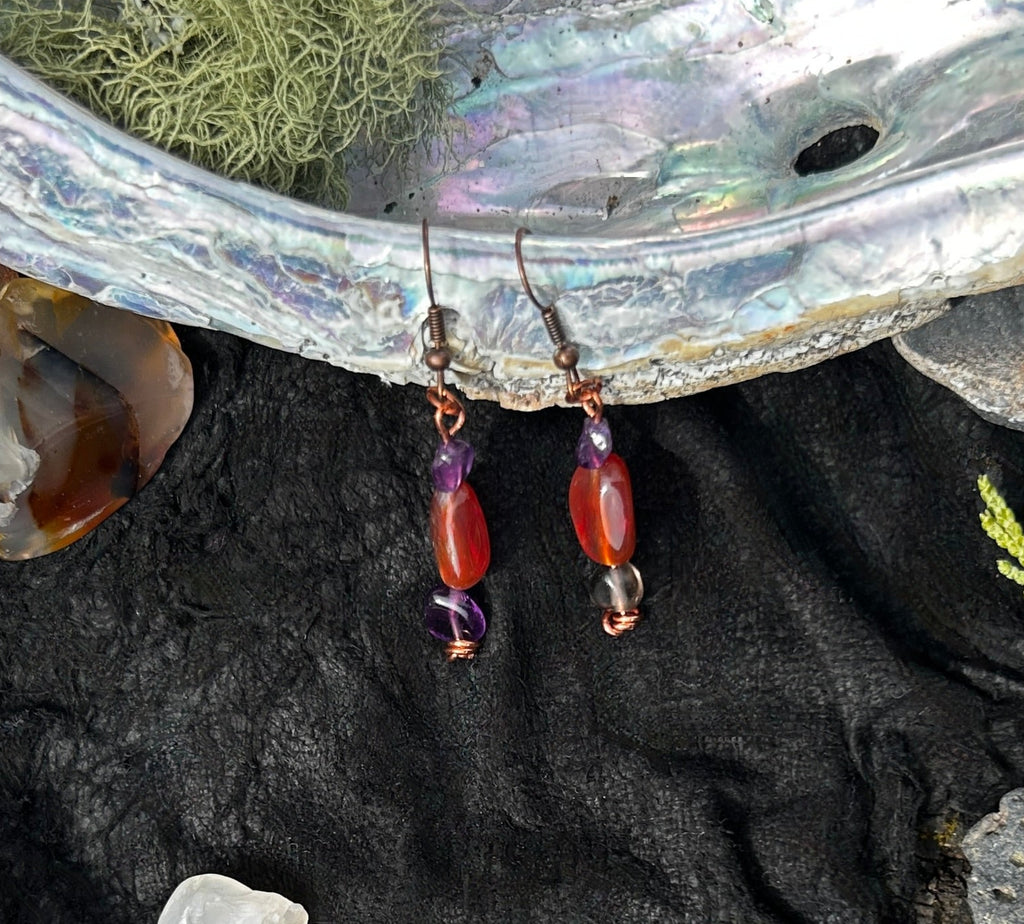 Copper, Carnelian and  Amethyst earrings on a black background.